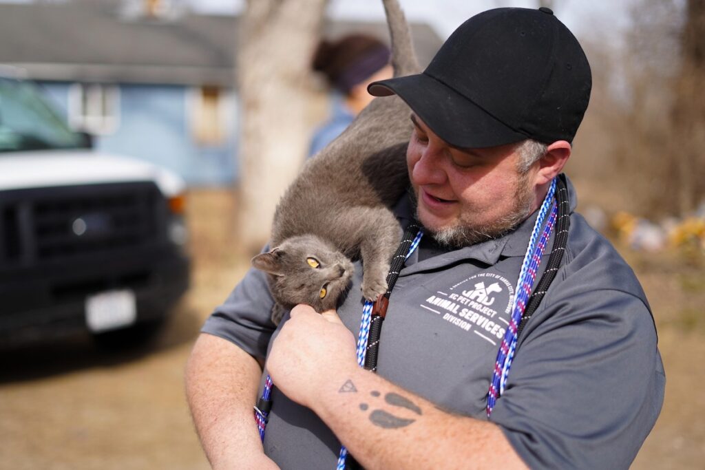 kc pet project animal services officer snuggles a cat